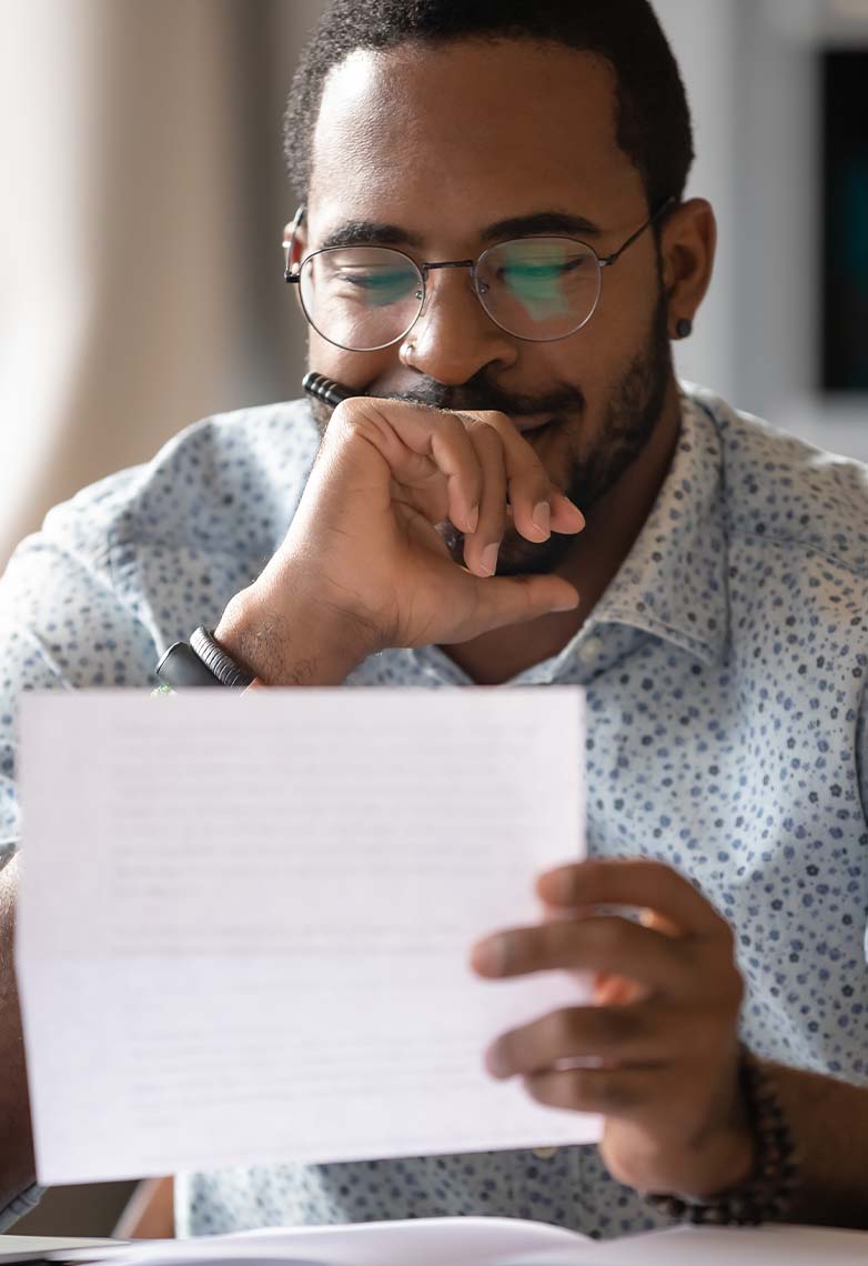 Man smiling whilst holding a piece of paper Man smiling whilst holding a piece of paper