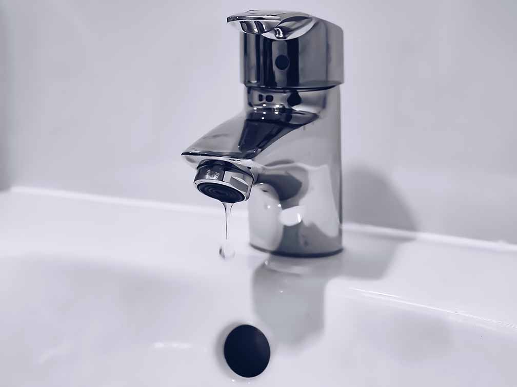 Modern silver tap dripping water Modern silver tap dripping water