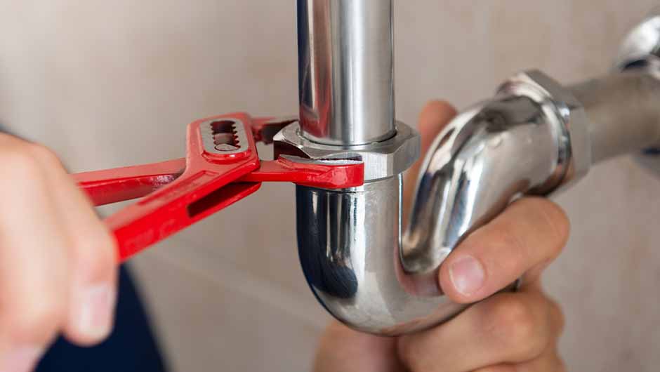 Plumber tightening silver pipe fitting Plumber tightening silver pipe fitting