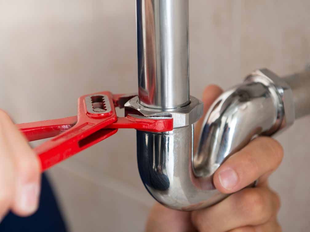 Plumber tightening silver pipe fitting Plumber tightening silver pipe fitting