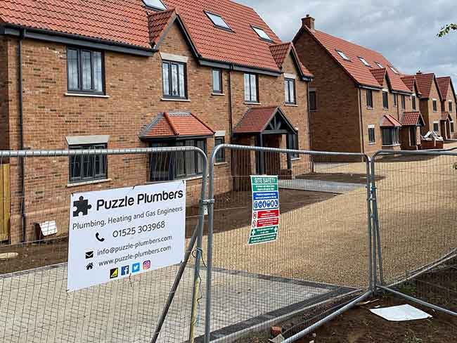 Puzzle Plumbers sign on site fencing Puzzle Plumbers sign on site fencing