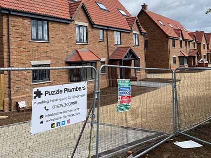 Puzzle Plumbers sign on site fencing Puzzle Plumbers sign on site fencing