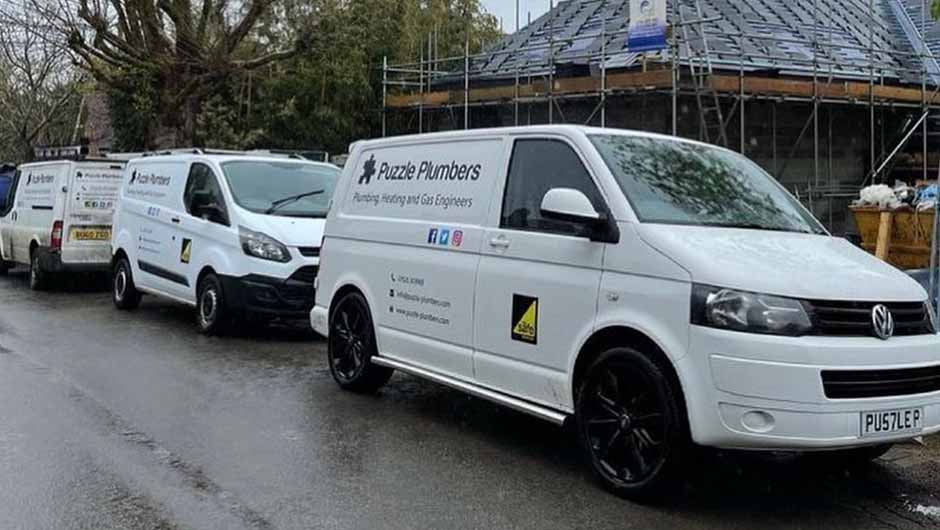 Puzzle Plumbers vans in front of new build house Puzzle Plumbers vans in front of new build house