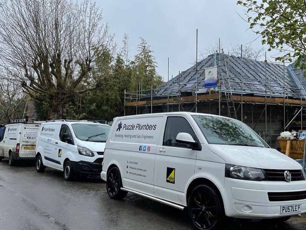 Puzzle Plumbers vans in front of new build house Puzzle Plumbers vans in front of new build house